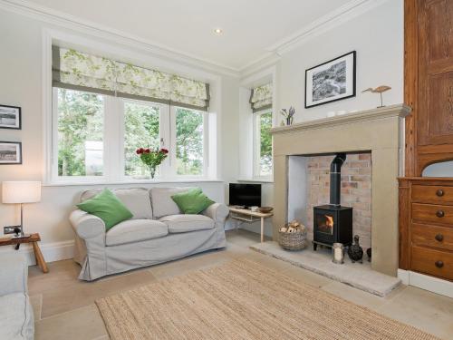 a living room with a couch and a fireplace at The Gatehouse Beckfoot Hall in Great Musgrave