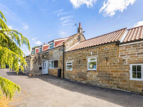 an old brick house with a driveway in front of it at Rigg Farm Cottage in Stainsacre