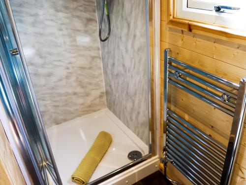 a shower stall with a wooden stick on the floor at Bryn Hafod - Uk49671 in Brynsiencyn