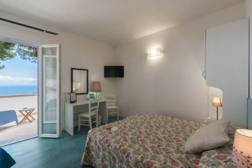 a bedroom with a bed and a view of the ocean at Hotel Sant'Andrea in Marciana