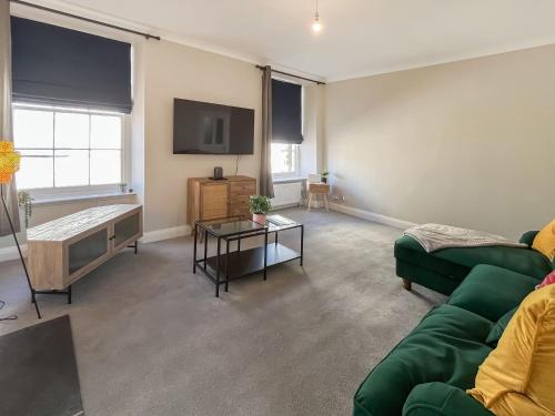 a living room with a green couch and a table at Murray Street Town House in Duns