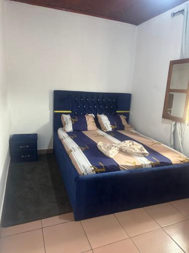 łóżko z niebieską ramą w pokoju w obiekcie Colbel appartement w mieście Jaunde