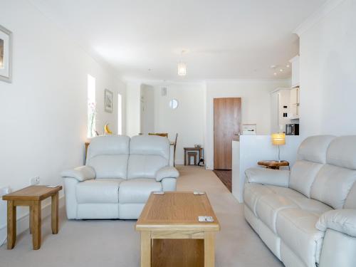 a living room with two white couches and a table at Bay View in Shanklin