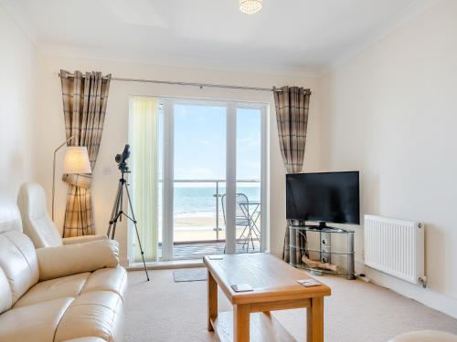 a living room with a couch and a view of the ocean at Bay View in Shanklin