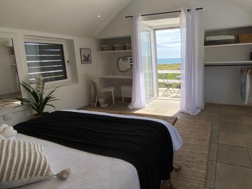 a bedroom with a bed and a view of the ocean at Namaste - Sea-facing 4 sleeper Holiday Home in Paternoster