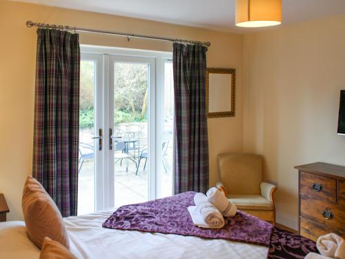 a bedroom with a bed and a sliding glass door at Roslin Chapel Lodge - Uk49194 in Roslin