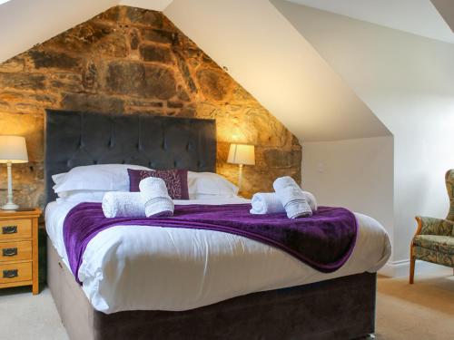 a bedroom with a large bed with towels on it at Roslin Chapel Lodge - Uk49194 in Roslin