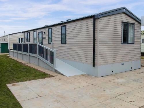 a large house with a large deck on a yard at Serenity in Ingoldmells