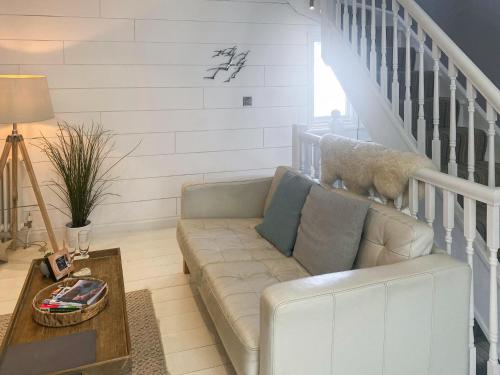 a living room with a couch and a dog standing on the stairs at Gylly Cottage in Mousehole