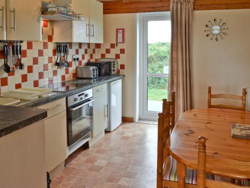 a kitchen with a table and a dining room at Brambles in St. Agnes