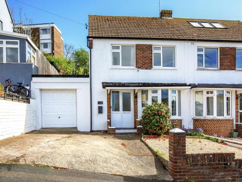 a white house with a garage at Driftwood Villa in Brixham