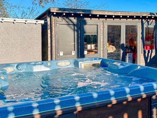 ein großer blauer Whirlpool vor einem Haus in der Unterkunft Follonsby Foal Cottage in Hebburn-on-Tyne