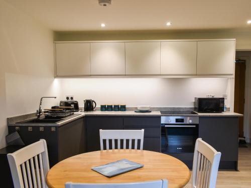 a kitchen with a wooden table and a table and chairs at St Andrews Place in Stratton