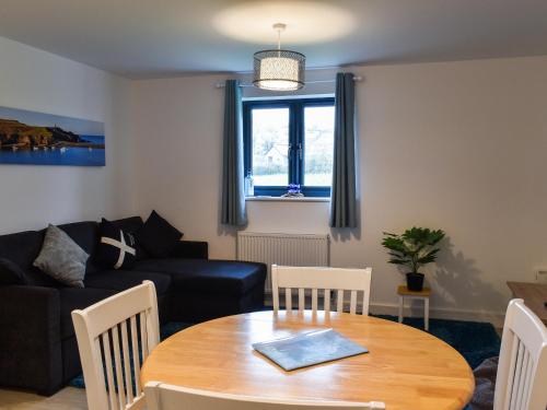 a living room with a table and a couch at St Andrews Place in Stratton