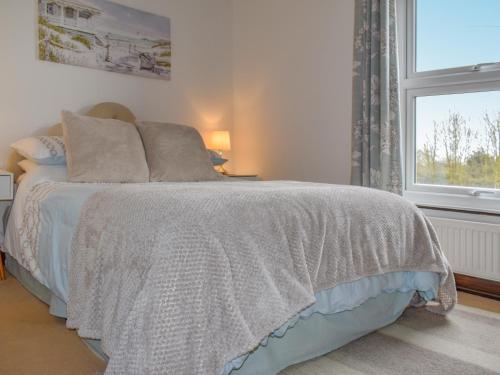 a bedroom with a bed with a window and a bedspread at Kathys Cottage in Kings Lynn
