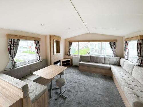 a living room with a couch and a table at Baillies Retreat - Uk49970 in Chapel Saint Leonards