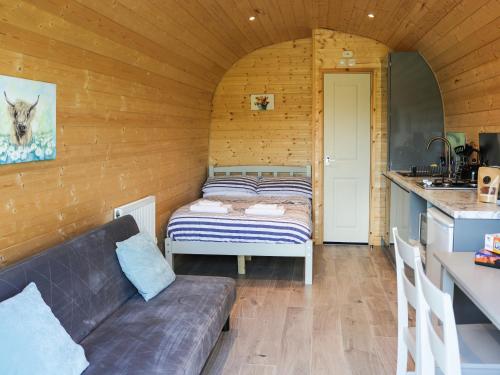 a room with a couch and a bed in a kitchen at Awel Deg - Uk49672 in Brynsiencyn