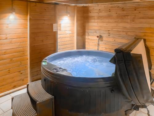 a large hot tub in a wooden room with a bench at Log Cabin in Guyhirn
