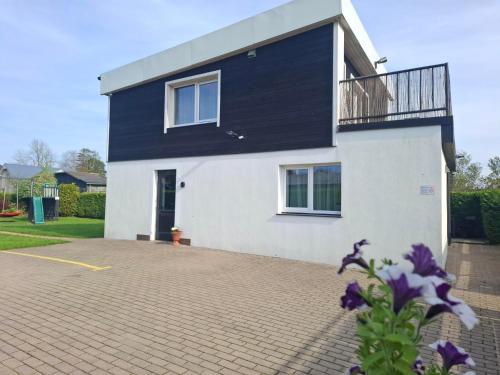 a house with a black and white facade at 4 Bedroom House with Playground, BBQ & Free Parking in Rīga