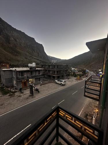 einen Balkon mit Blick auf eine Straße und Gebäude in der Unterkunft Glampfire Hotel and Cafe in Jispa