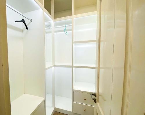 a white walk in closet with white shelves at Eco Hotel Tran Hung Dao - Old Quater in Hanoi