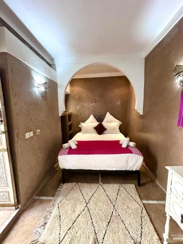 a bedroom with a bed with a red and white blanket at Riad Green Palm in Marrakech