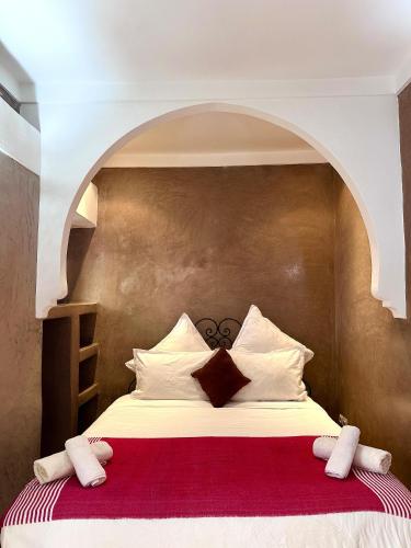 a bedroom with a bed with an arch above it at Riad Green Palm in Marrakech