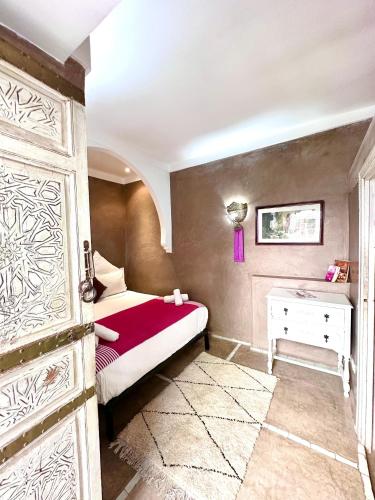 a bedroom with a bed and a table and a door at Riad Green Palm in Marrakech