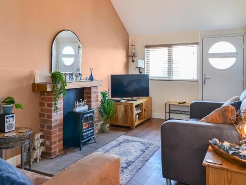 Una sala de estar con chimenea y televisión. en Beachcroft, en Bridlington