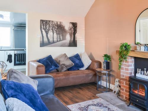 Una sala de estar con un sofá y una chimenea. en Beachcroft, en Bridlington