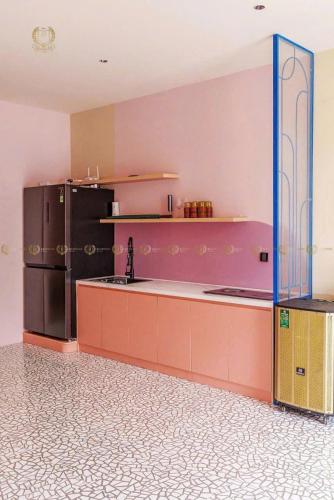 a kitchen with a refrigerator and a counter top at Hoàng Gia villa Novaworld in Bình Sum