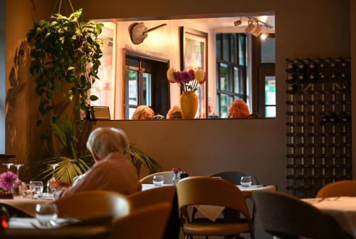 a woman sitting at a table in a restaurant at The Bakery B&B in Westerham