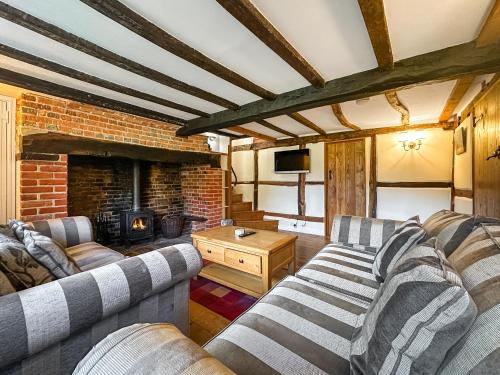 a living room with two couches and a fireplace at Poona Cottage in Cadnam