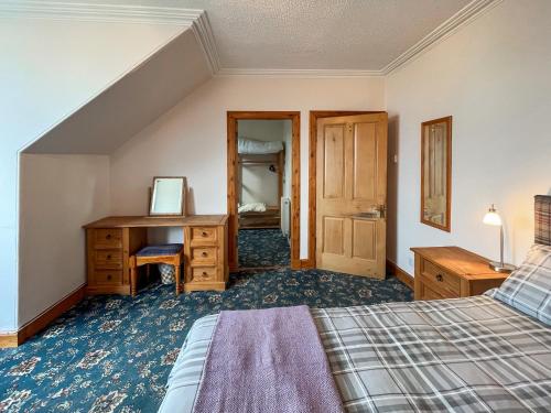 a bedroom with a bed and a desk and a mirror at Glengilp Apartment - Uk49317 in Ardrishaig