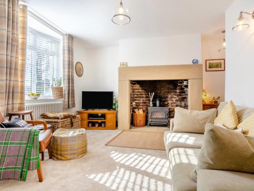 a living room with a couch and a fireplace at Nook Cottage in Durham