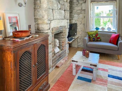 ein Wohnzimmer mit einem Steinkamin und einem Sofa in der Unterkunft Mallams Art House in Castletown