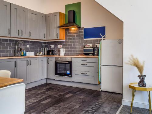 a kitchen with white cabinets and a refrigerator at South Pier Apartment in Blackpool