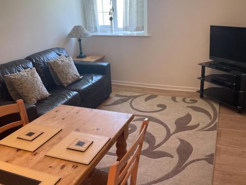 a living room with a table and a couch at Goldfinch Apartment - Uk49296 in Woolfardisworthy