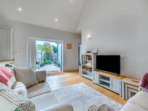 a living room with a couch and a flat screen tv at Lavender Barn in Heacham