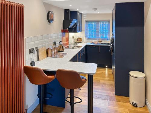 a kitchen with a counter and two stools in it at Lily Pad - Uk49104 in Helmsley