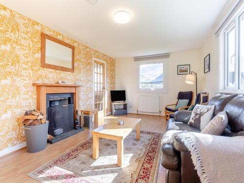 a living room with a couch and a fireplace at Walled Cottage - Uk49097 in Inchnadamph