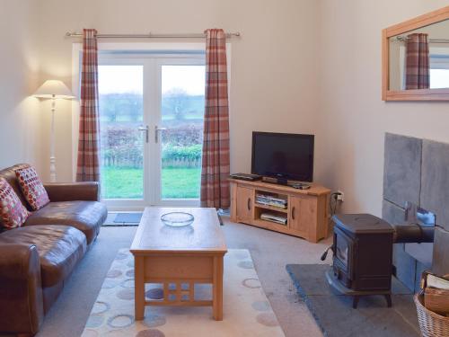 un soggiorno con divano e TV a schermo piatto di Kilfillan Cottage a Garlieston