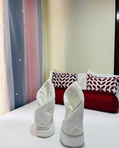 a pair of white shoes on a bed with a couch at Free Breakfast and coffee for 2 Purple Beach House in Pilar