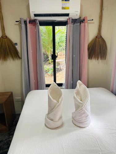 a pair of white shoes sitting on top of a bed at Free Breakfast and coffee for 2 Purple Beach House in Pilar