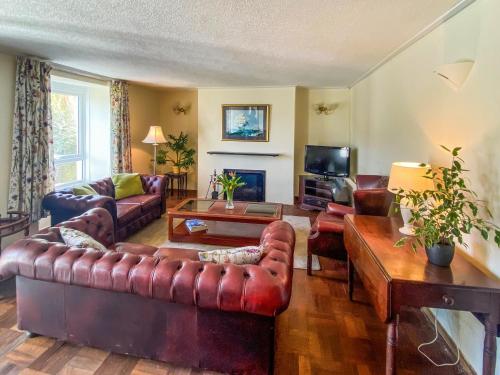 un salon avec un canapé en cuir et une télévision dans l'établissement Riverside, à Truro