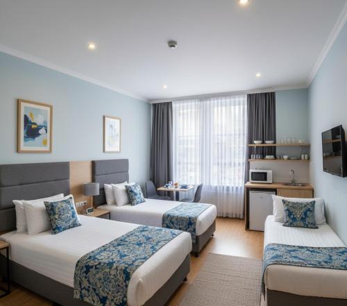 a hotel room with two beds and a living room at Arsuz yas Apart in Arsuz