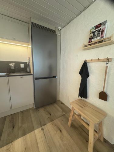 a room with a wooden bench and a refrigerator at Nyrenoverad 2-rummare med gratis laddning för elbil in Bankeryd