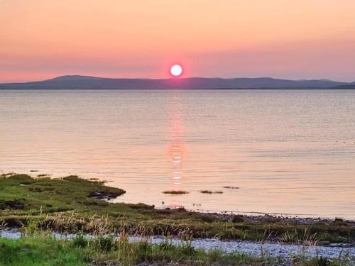 a sunset over a body of water with the sun setting at Ocean Breeze in Heysham
