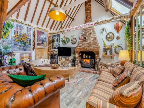 a living room with leather furniture and a fireplace at Hideaway in Beccles