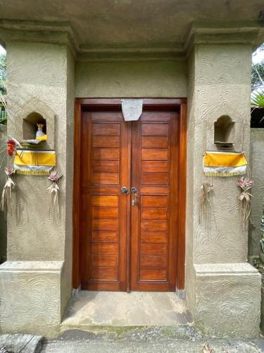a wooden door on the side of a house at Kamanaya Ubud in Ubud